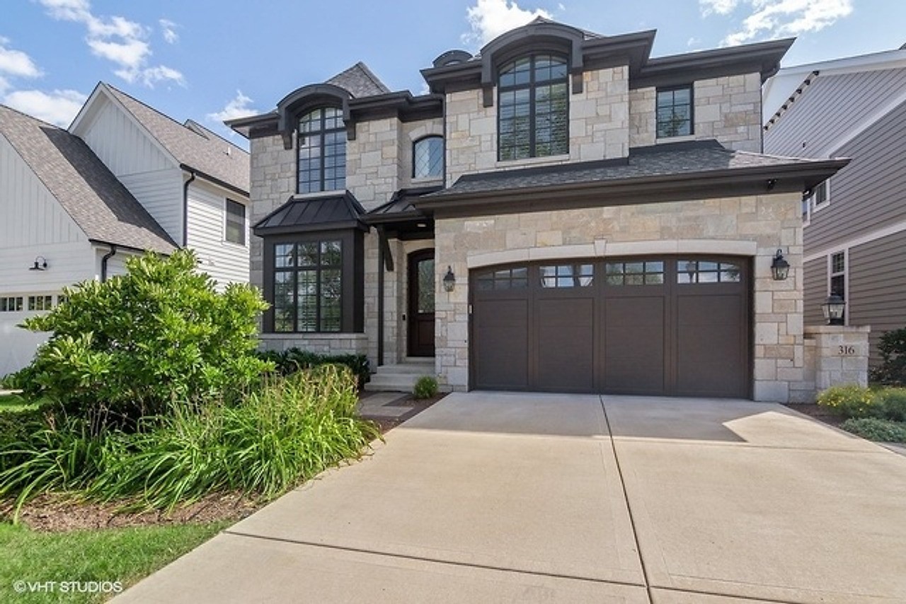 Stone and shingle home with an arched entry and a deep drive, a Gimbel Group listing