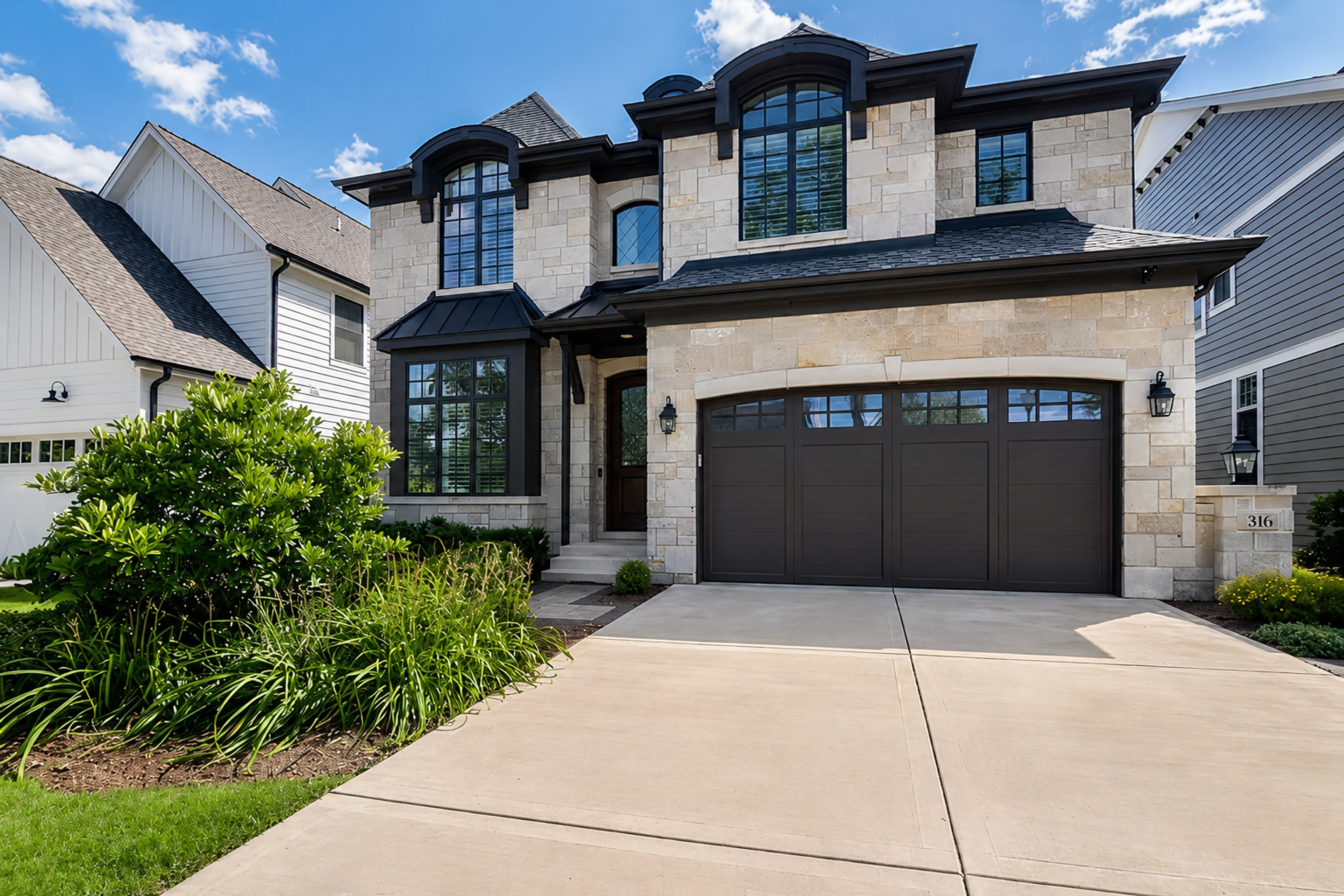 Stone and shingle home with an arched entry and a deep drive, a Gimbel Group listing