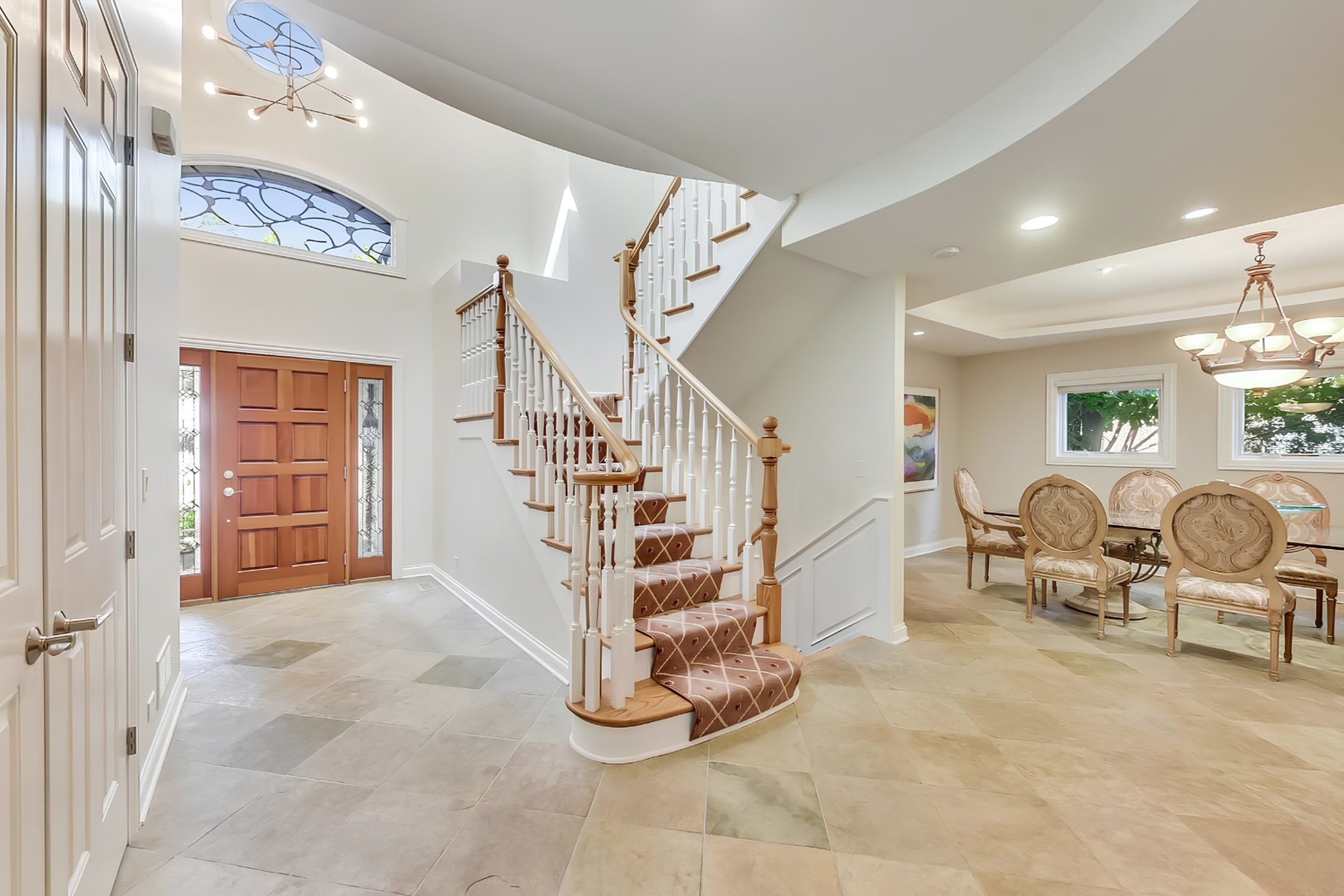 Two-story foyer with a curved staircase in a Gimbel Group listing